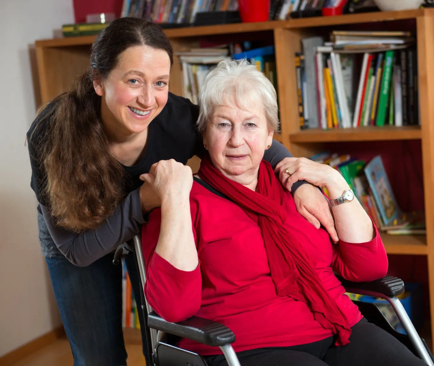 Pflegeteam mit Hand und Herz, eine Krankenschwester legt einer alten Dame tröstend die Hände auf die Schultern