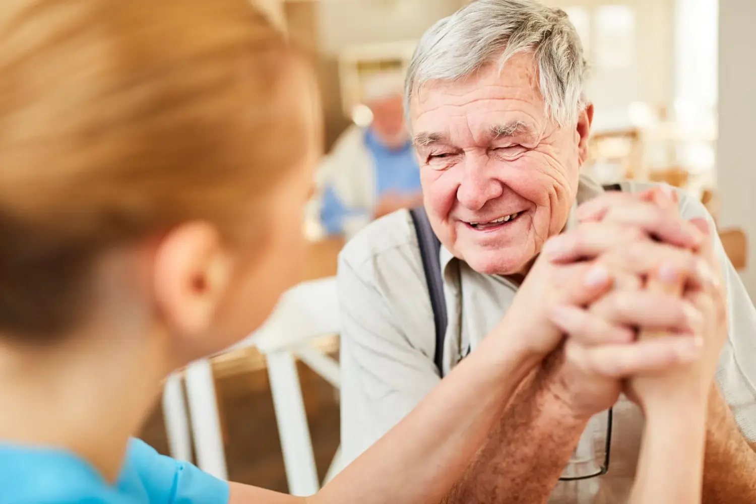 Pflegeteam mit Hand und Herz, Krankenschwester hält die Hände eines alten Mannes